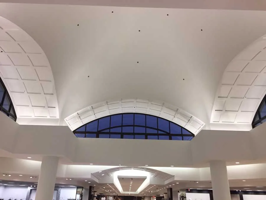 Looking up at the ceiling of a building with arched windows